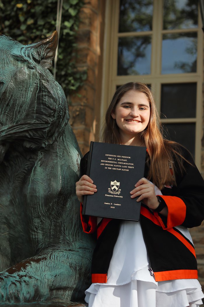 Jessica Lambert holds up her senior thesis.