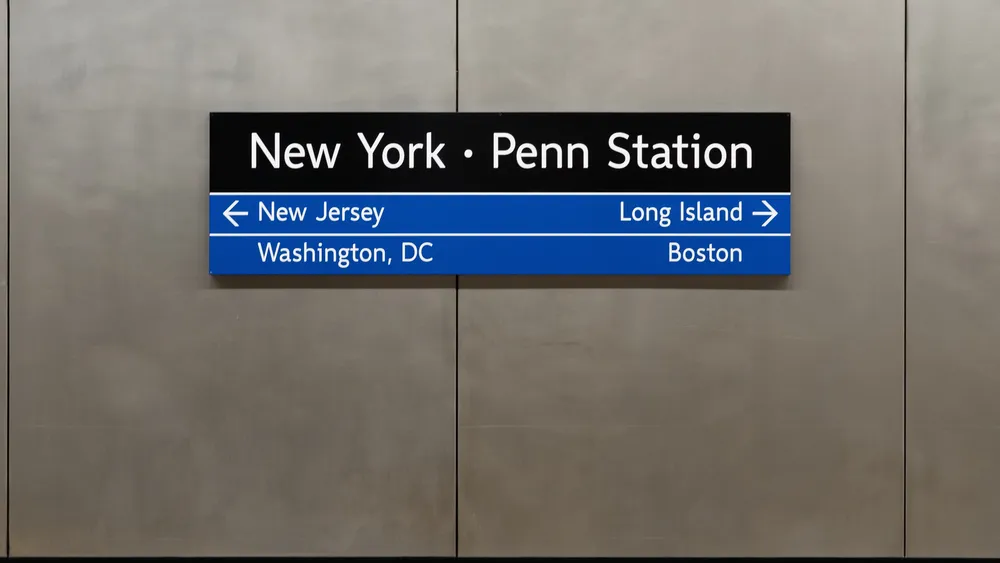 A sign reads "New York Penn Station" with arrows to New Jersey and Long Island