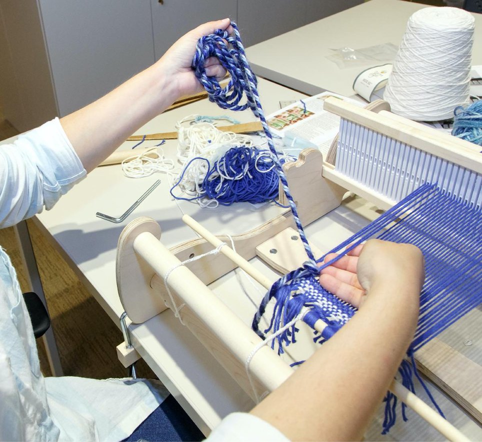 A person weaving on a loom