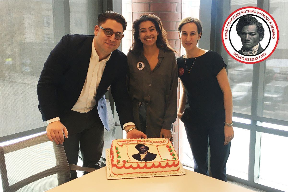 From left, Perkins Postdoctoral Fellow Jim Casey and CDH University Administrative Fellows Elena M'Bouroukounda and Julia Grummitt pose with a birthday cake during Princeton's Douglass Day event. Born into slavery, Frederick Douglass did not know his birthday, so he chose February 14 to celebrate.